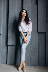 Photo session of a young brunette in jeans and a white shirt.