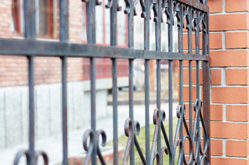 Forged fence along the high-rise building in the city. Selective focus