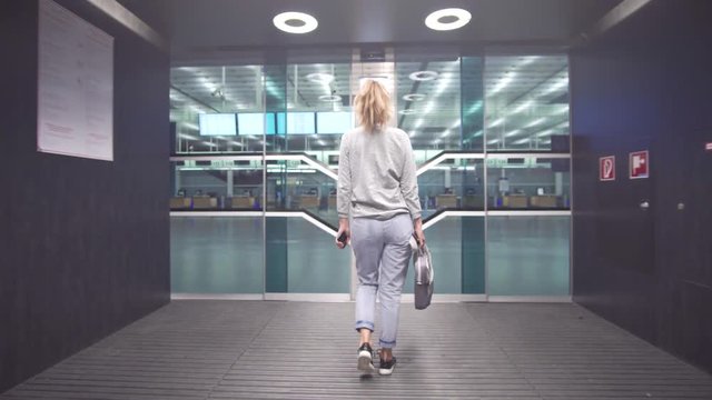 Female passenger traveler checking information of boarding pass ticket and on schedule board preparing for flight departure.