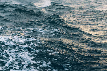 ripples on blue sea water with white foam , natural sea background