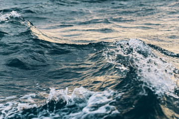 ripples on blue sea water with white foam , natural sea background