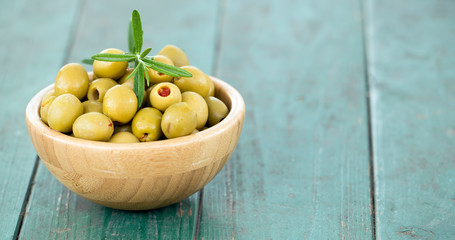Web banner of green olives on wooden background with copy space