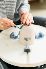 Women working on the potter's wheel in the studio, ceramic cup