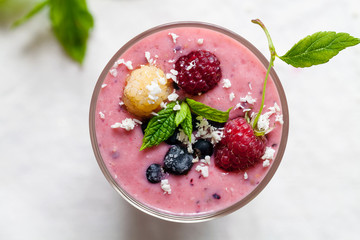 Raspberry and blackcurrant smoothie with almonds, granola and coconut topping
