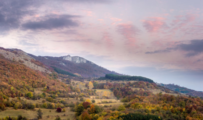Fototapeta premium Panorama of stunning autumn colors of mountain forest and beautiful sunset sky