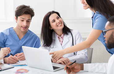 Fototapeta premium Medical Meeting. Successful Doctors Using Laptop In Hospital