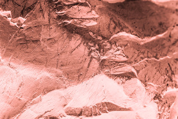 Vintage pink background. Rough painted wall of living coral color. Imperfect plane of beige colored. Uneven old decorative toned backdrop of beige tint. Texture of pink hue. Ornamental stony surface.