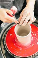 Fototapeta na wymiar Women working on the potter's wheel in the studio, ceramic cup