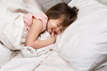 Cute little child girl sleeping in her bed. child wakes up