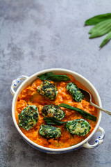Spinach and ricotta dumplings in tomato and courgette sauce 
