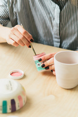 the pottery woman holds in hands a mug to paint the ornament