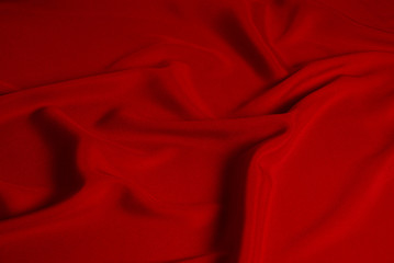 Red silk or satin luxury fabric texture can use as abstract background. Top view.