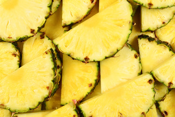 Pineapple juicy yellow slices background. Top view.