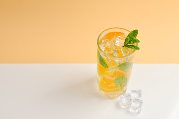 Cocktail with lemon and mint on a beige background. Copy space.