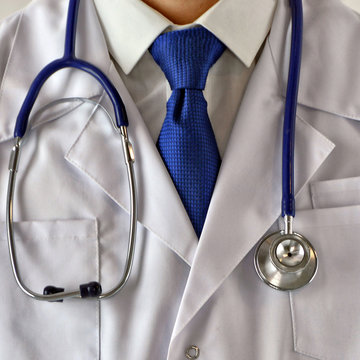 Medical content. Medicine. Doctor in white uniform with a stethoscope. Treatment. Conceptual image. Close up photo.