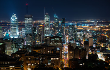 Night view of Montreal skyline with tall skyscrapers and busy street