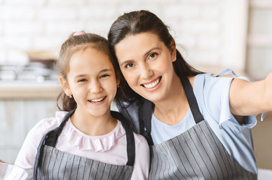 Cute Little Girl And Her Mom In Aprons Making Selfie