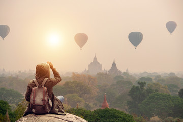 Backpacker traveler in Bagan Mandalay Myanmar and sitting watching balloon air in the morning at...