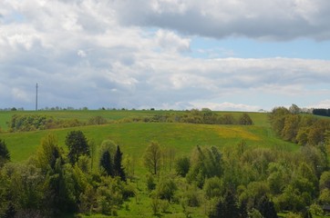Hügellandschaft im Frühling unter Wolkenhimmel