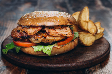Classic american hamburger with french fries on a wooden board