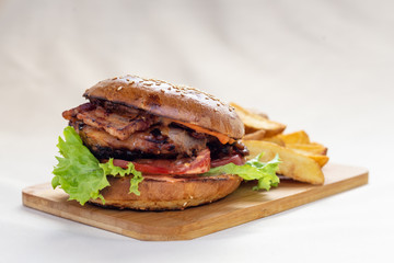 Classic american hamburger with french fries on a wooden board