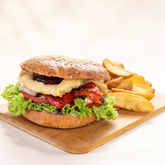 Classic american hamburger with french fries on a wooden board