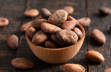 Bowl of Cocoa Beans on a Dark Wooden Table