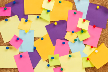 Papeles post it sobre tablón de anuncios de corcho