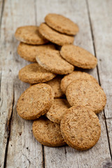 Fresh baked homemade oat cookies on rustic wooden table.