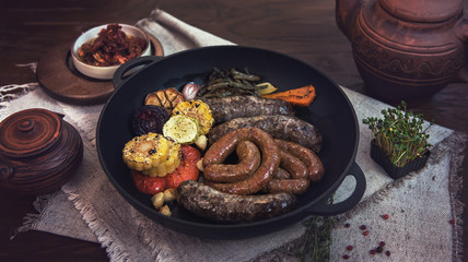 Grilled different meat sausages with vegetables and spices