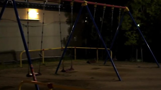Kyoto, Japan empty playground at night in slow motion with creepy swings swinging and nobody in slow motion