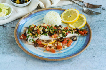 Mediterranean sea bass stuffed with tomatoes, lemons, fennel and olives. Greek cuisine.