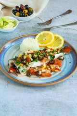 Mediterranean sea bass stuffed with tomatoes, lemons, fennel and olives. Greek cuisine.