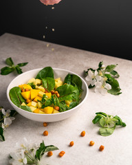 exotic mango salad, in a white bowl, lemon juice drops falling on top