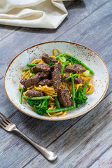 Honey and sesame beef noodles with green vegetables - high angle view