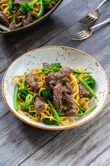Honey and sesame beef noodles with green vegetables - high angle view