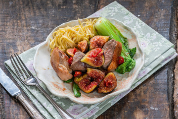 Oriental duck fillets with sticky figs, pak choi and egg noodles - high angle view