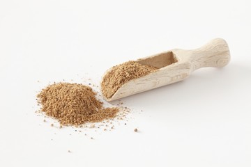 Ground nutmeg on wooden spoon