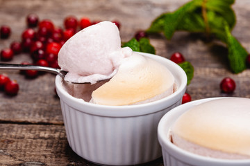 Souffle with cranberries in white ramekin on wooden rustic table. Close up