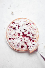 Whole cherry cake with almond petals on white background with cherry flowers.