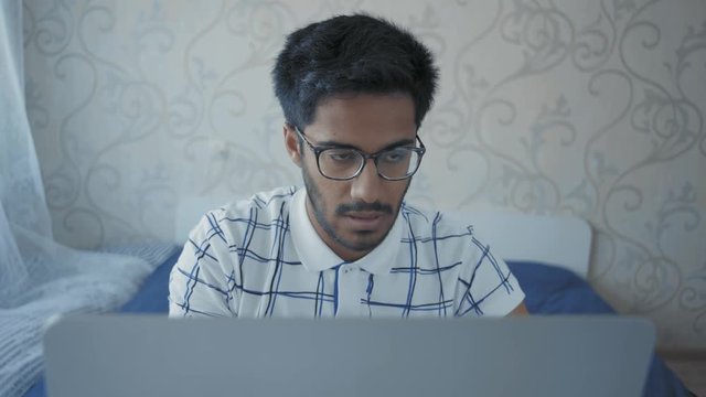 Close-Up, Indian Student in Glasses Yawns from Fatigue Sitting at the Laptop