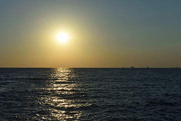 Fototapeta premium Beautiful orange sunset in the black sea with sun reflection in the city of Gelendzhik, Russia