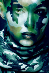 Beautiful young fashion woman with military style clothing and face paint make-up, khaki colors, halloween celebration