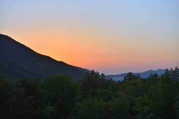 Evening landscape with mountains overgrown with trees against a sunset. Beautiful mountains around Geledzhik, Russia