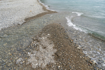 Little Mountain River flows into the Black Sea on the coastline of a stone beach