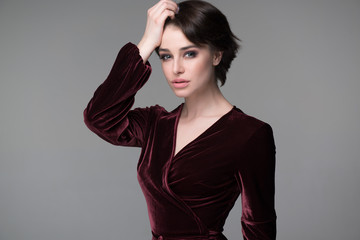 Beauty female portrait. Young attractive woman posing at studio over gray background. Beautiful...