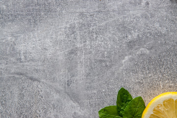 Plasterek cytryny oraz liście mięty na betonowym tle © andsko