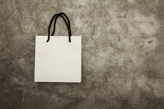 White paper bag package on gray background. Place for text. Mock up concept for gift wrapping.
