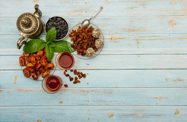 Traditional Arabic, Turkish Ramadan tea with dry dates and raisins on a wooden white table. A cup of tea on a white table.Turkish fresh tea with dates. Ramadan kareem. Ramadan background. 