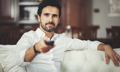 Portrait of a man choosing a program to watch on television